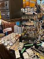 Wide view of rack with earrings, bagged bracelets and assorted jewelry