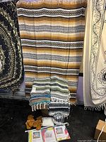 Folded Mexican blankets, sandals, disco ball, packaged door curtain, striped textile backdrop