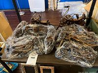 Multiple plastic-wrapped wooden motorcycle models on shelf