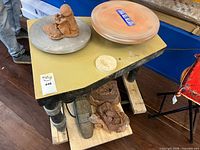 Top view of pottery wheel with clay model and additional wheel head