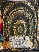 Full lot showing packaged tapestries, sandals, disco ball, rolled curtain; black-gold mandala backdrop not included
