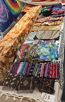 Table with tapestries, woven pouches, hats and purses displayed