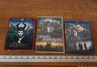 All three movie cases side by side with ruler for scale