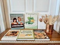 All five cookbooks, copper holder and wooden utensils displayed