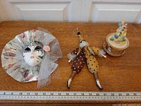 Lot overview showing mask, doll, music box with ruler for scale