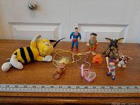 Group shot of all nine toys and figures with ruler for scale