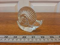 Snail figurine front view beside ruler showing length about 3 inches