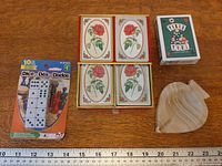 All items together showing dice pack, Rose playing cards set, Poker Pool deck, calcite dish with ruler for scale