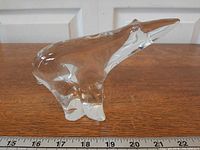 Left side view of clear crystal polar bear figurine with ruler for scale