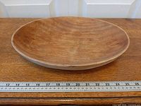 Top view of entire wooden bowl with ruler for scale