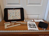 Entire Scrabble travel set displayed: folio case open with board, tiles, racks, pouch, instructions and score pad