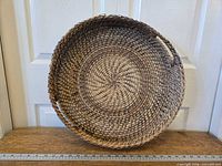 Full view of round rattan tray front showing weave pattern and handles