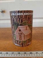 Front view of cylindrical package showing product name and finished birdhouse image