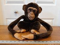 Full view of plush puppet with ruler showing size and long arms