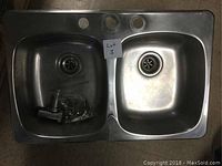 Top view of the stainless steel double basin sink showing two basins, strainer drains, and three faucet holes.