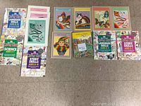 Top view of 14 children's educational books laid out in two rows on a floor, focusing on language skills, study skills and science for ages 5 to 10.