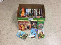 Photo showing a box filled with Piers Anthony paperback fantasy books arranged vertically and some displayed in front of the box on the floor.