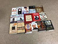 Top view of 17 books arranged in rows on floor showing various titles including fiction and non-fiction.
