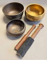 Group of three singing bowls and two mallets