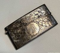 Front view showing scroll engraving, monogram and clasp