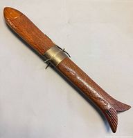 full view of carved wood fish sheath with brass locking band