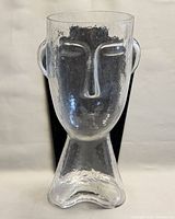 Front view of clear glass vase showing facial features
