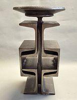 Front view of iron pillar candle holder showing stacked I-beam design