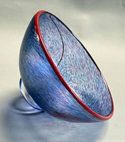 Side view showing blue mottled bowl, red rim, clear foot