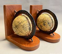 Front angled view of both wooden globe bookends