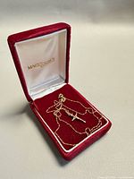 Chain and crucifix pendant displayed in red Mackenzie jewelry box