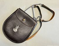 Front view of brown leather sporran with crest badge and chain strap