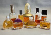 Group of ten assorted perfume bottles showing shapes, caps and fill levels