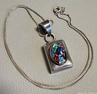 Necklace laid flat displaying pendant and chain