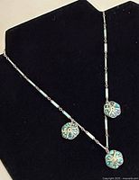 Necklace displayed on black bust showing full hanging length and pendant arrangement