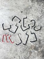All 13 screw-in hooks laid out on concrete floor showing shapes and finishes