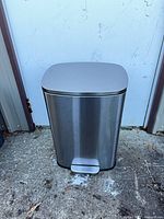 Front view of stainless steel step-pedal trash can showing foot pedal and brushed finish