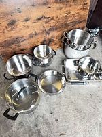 All cookware pieces laid out on concrete floor