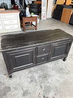 Angled view of entire distressed wood cabinet showing top, doors, drawers and overall wear