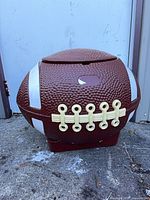 Front view of football-shaped container showing lace detail and overall condition