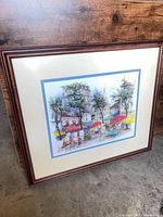 Framed color print of city scene with brown frame and mat