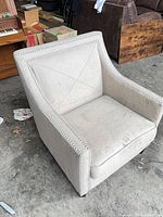 Front angled view showing fabric, nailhead trim, cushion condition, wood legs