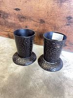 Pair of hammered dark metal candle holders upright