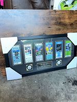 Front view showing six ticket replicas, logo medallions, central plaque in landscape wood frame