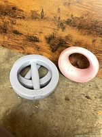 Pink donut-shaped 5 lb grip weight and purple circular grip weight with handles