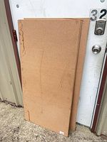 Stack of MDF panels leaning against door showing size and edge staining