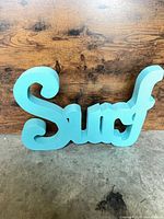 Front view of teal Surf script wall sign