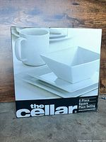 front of box showing The Cellar branding and image of square white dinnerware
