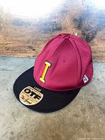 Cap front and top view showing burgundy crown, black brim, front yellow “I” logo and original sticker