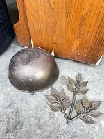 Bowl and leaf plaque together on concrete floor for size and condition reference