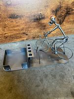 Front view of welded metal bicycle sculpture with pen holder and tray